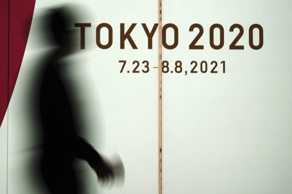 일본 도쿄에서 코로나19 확산을 막기 위해 마스크를 쓴 한 남성이 2020 도쿄 올림픽 광고판 앞을 지나고 있다.(도쿄=AP) ⓒ뉴시스