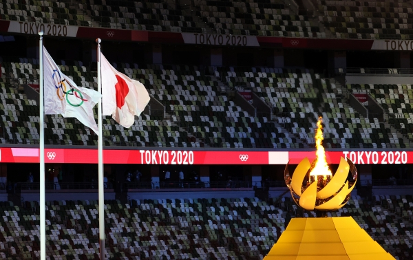 도쿄 신주쿠 국립경기장에서 열린 2020 도쿄올림픽 개막식에서 타오르는 성화대 옆으로 오륜기와 일장기가 휘날리고 있다. (공동취재사진)ⓒ뉴시스