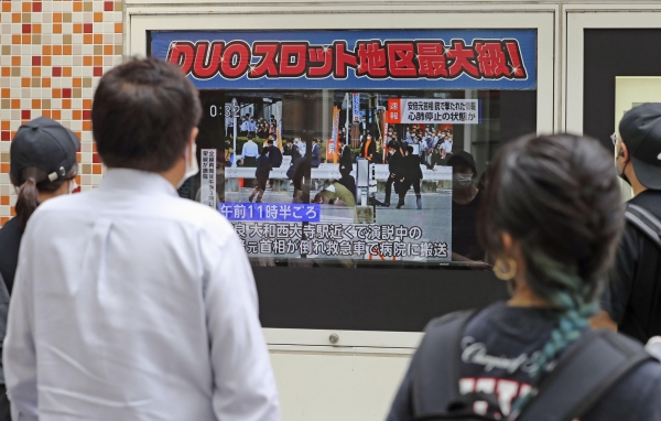 [도쿄=AP/뉴시스] 8일 일본 도쿄에서 시민들이 TV를 통해 아베 신조 전 총리의 피격 소식을 지켜보고 있다. 아베 전 총리는 나라에서 참의원 선거를 앞두고 선거 유세 중 총성과 함께 가슴 부위에 피를 흘리며 쓰러져 심정지 상태로 병원으로 옮겨졌다.