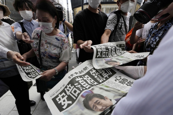 [도쿄=AP/뉴시스] 8일 일본 도쿄에서 요미우리 신문사 직원들이 아베 신조 전 총리의 피격 소식을 전하는 호외판을 배포하고 있다.