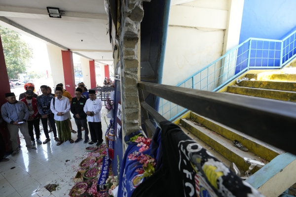 지난 10월 4일(현지시간) 인도네시아 말랑 리젠시의 칸주루한 축구장 13번 출입구 앞에서 시민들이 축구장 참사 희생자들을 위해 기도하고 있다. 현지 당국은 지난 1일 발생한 축구장 참사 당시 희생자 125명 중 어린이가 17명 포함됐다고 밝혔다. ©뉴시스