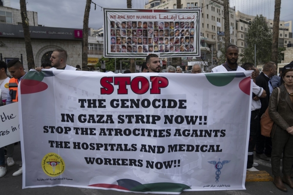 지난 12일(현지시각) 요르단강 서안지구 라말라에서 팔레스타인 의료 종사자들이 가자지구 의료 붕괴에 항의하는 집회에 참석해 이스라엘을 비난하는 손팻말을 들고 있다.©AP/뉴시스